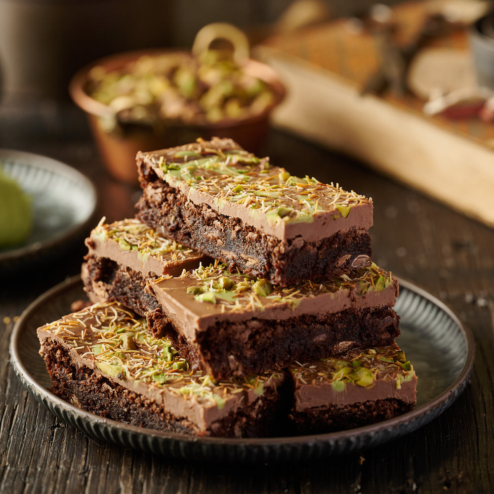 Decadent Dubai-inspired pistachio brownie with roasted nuts, creamy topping, and crunchy kunafa strands