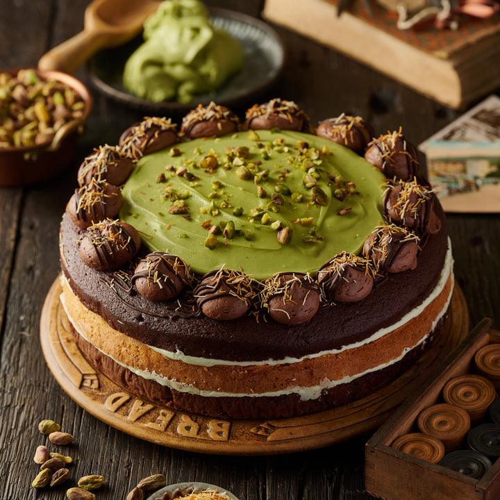 Dubai Style Chocolate Cake featuring rich chocolate layers with roasted pistachios and a smooth pistachio cream swirl, topped with milk chocolate and kunafa strands