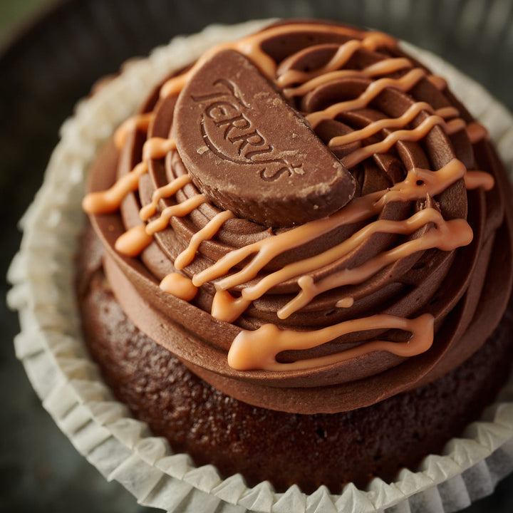 Luxury Chocolate Orange Cupcake topped with orange drizzle and a segment of chocolate orange