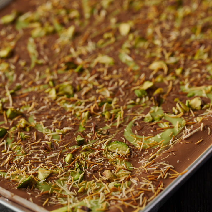 Luxury pistachio brownie  with rich chocolate, chopped nuts, and crispy kunafa topping