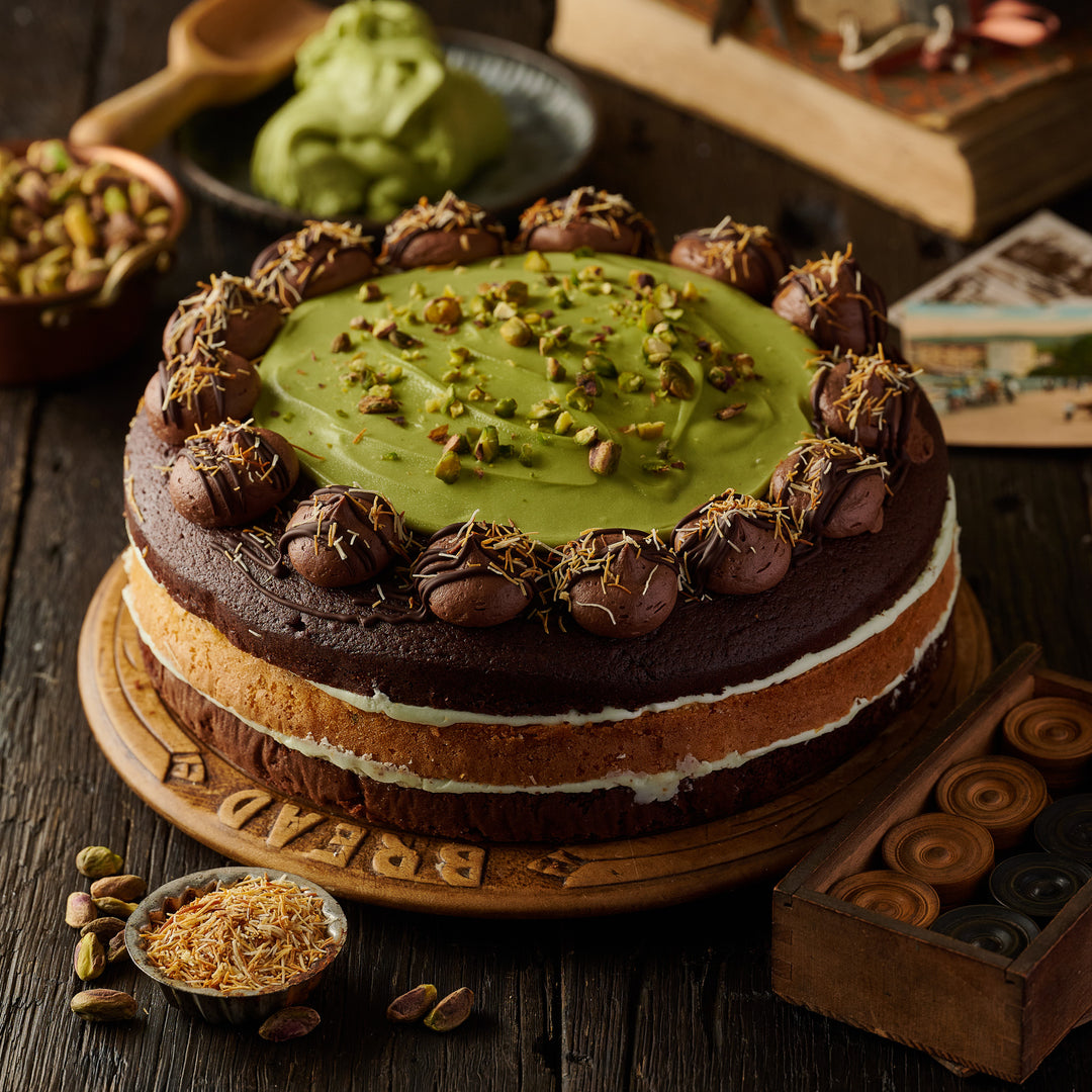 Premium Dubai Style 3 layered luxury cake with rich chocolate, roasted pistachios, pistachio cream swirl, milk chocolate topping, and golden fried kunafa strands