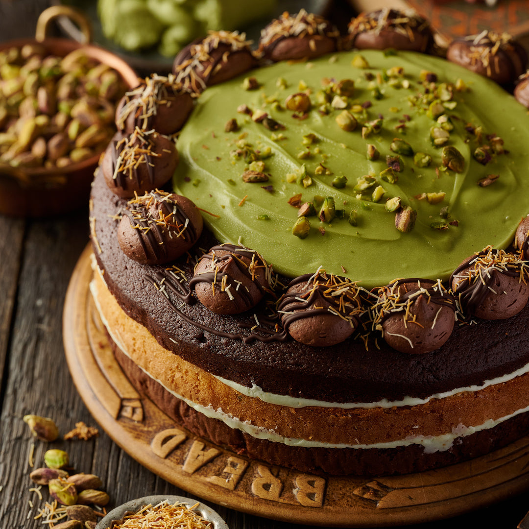 Premium Dubai Style 3 layered luxury cake with rich chocolate, roasted pistachios, pistachio cream swirl, milk chocolate topping, and golden fried kunafa strands