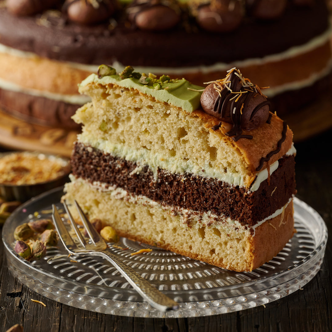 Premium Dubai Style 3 layered luxury cake with rich chocolate, roasted pistachios, pistachio cream swirl, milk chocolate topping, and golden fried kunafa strands