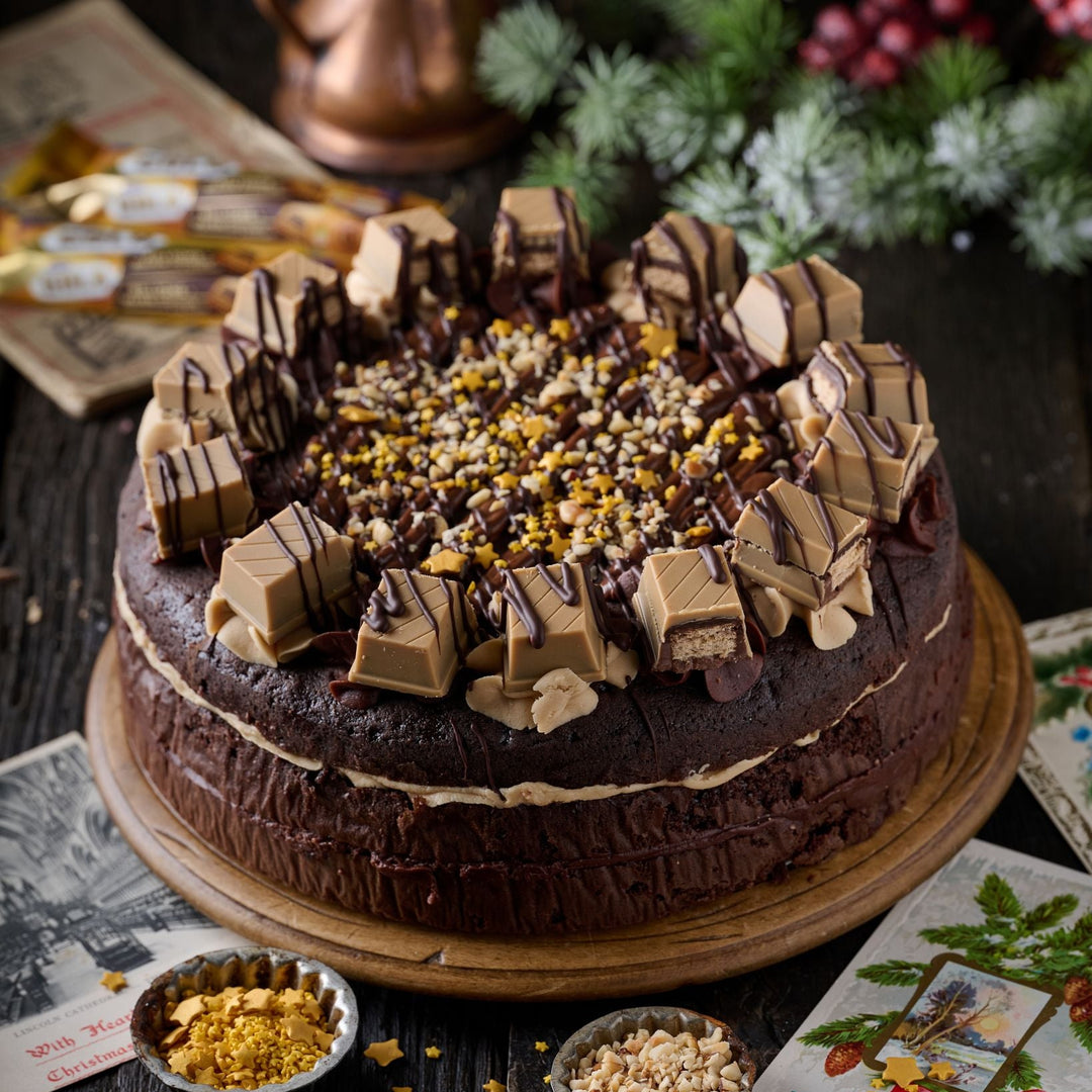 Chocolate cake with festive decorations on a wooden table with Christmas-themed elements.