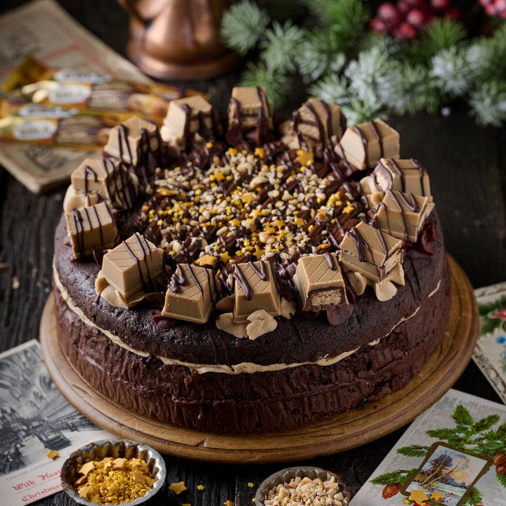 Chocolate cake with festive decorations on a wooden table with Christmas-themed elements.