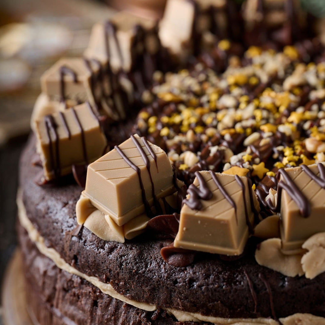 Chocolate cake with nuts and chocolate pieces on a wooden board